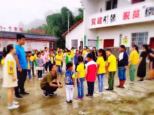 西南交通大学“砥力筑梦”暑期社会实践队队员与贫困地区小朋友们玩“萝卜蹲”游戏。
