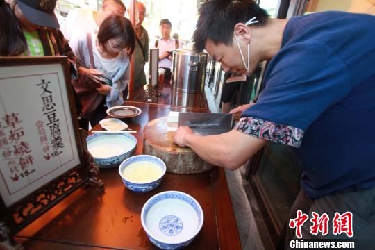 图为扬州厨师为游客表演淮扬菜经典“文思豆腐”的切制。　孟德龙 摄