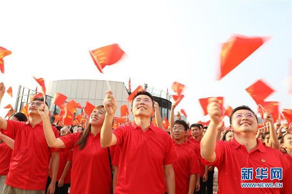 9月26日，在广东东莞民盈·国贸中心，粤港澳青年挥舞国旗，合唱《歌唱祖国》。新华社记者 李嘉乐 摄