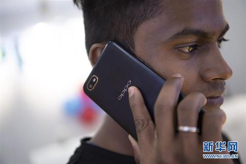 这是在印度金奈的一家商场，一名男子使用中国品牌OPPO的手机（2019年10月8日摄）。 新华社记者 吕小炜 摄