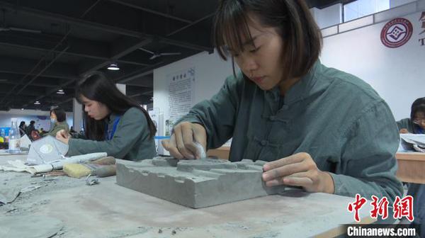 11月11日，在安徽黄山举办的全国砖雕传统技艺大赛上，年轻的女砖雕艺人正在忙碌着。　刘鸿鹤 摄