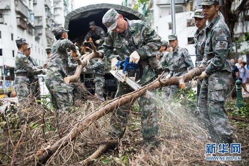 驻澳门部队官兵帮助抗击“天鸽”台风灾害，清理被风吹倒的树木（2017年8月27日摄）。 新华社发（叶华敏 摄）
