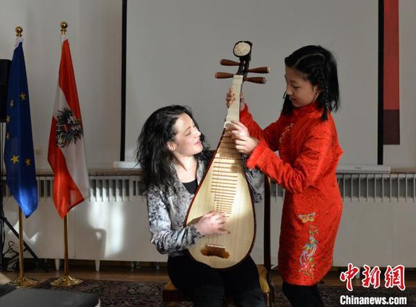 图为中国文化小使者琵琶独奏《彝族舞曲》，霓娜体验琵琶指法。主办方供图