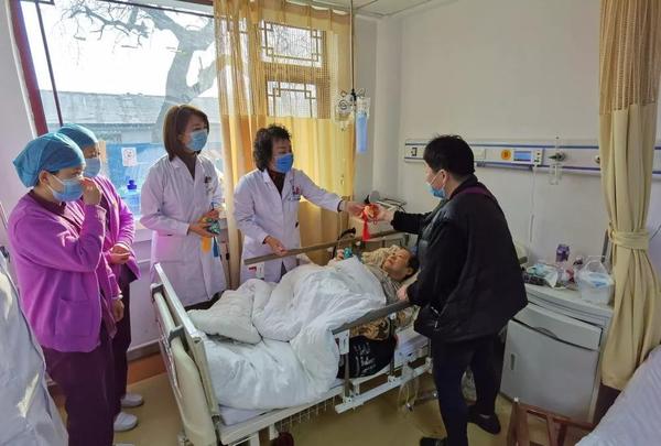 耿嘉玮委员（左四）向病人家属赠送医院自制的中药香囊