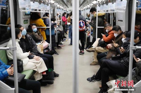 2月28日，乘客戴着口罩乘坐上海地铁出行。近日，随着上海企业全面复工，上海地铁客运量回升，高峰时段车厢满载率平均在五成左右。 中新社记者 殷立勤 摄
