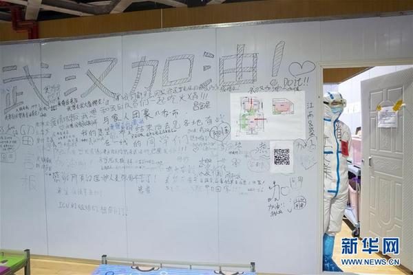 　3月9日晚，在武汉市洪山体育馆武昌方舱医院，医生江文洋站在一片留言板旁看着方舱里的“战友”和“病友”们。 新华社记者 沈伯韩 摄