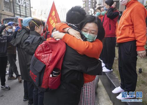 3月17日，在武汉市武昌区驻地，江西医疗队员（前右）拥抱送别青海医疗队员。青海医疗队当日返程，两家医疗队在同一个驻地也在同一个方舱共事，结下了深厚的感情。 当日，承担方舱医院医疗救治任务的援鄂医疗队陆续开始撤离。 新华社记者 才扬 摄