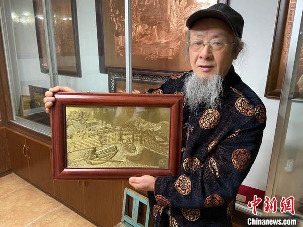赵秀林举着一幅蕴含绍兴风光的铜雕作品。　项菁 摄