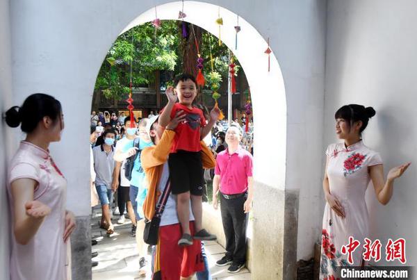 福州市民体验头顶状元道的门梁中间悬挂的粽子，寓意“粽状元，一举高粽”。　记者刘可耕 摄