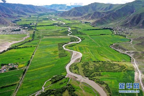 拉萨市林周县江热夏乡田园景色（7月14日摄，无人机照片）。 林周县地处西藏中部，拉萨河上游。夏日时节，这里水草丰茂，绿意盎然，河流、村落、农田组成一幅美丽的田园画卷。