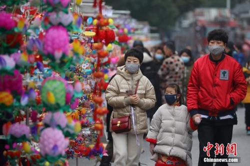 资料图：佩戴口罩的游客在南京夫子庙花灯市场游览。中新社记者 泱波 摄