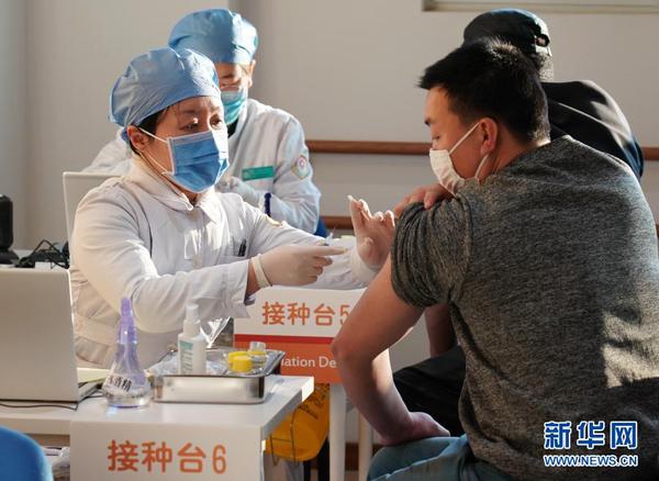 2021年1月3日，在位于北京市西城区广安门外街道红莲社区卫生服务站的接种点，医护人员为接种人员注射疫苗。