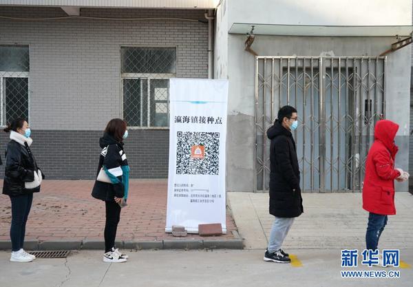 2021年1月3日，接种人员在北京市大兴区瀛海镇接种点排队等候接种疫苗。