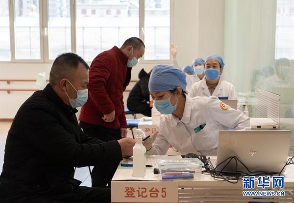2021年1月3日，在位于北京市西城区广安门外街道红莲社区卫生服务站的接种点，医护人员为接种人员进行接种前登记。
