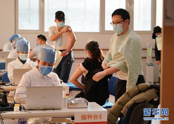 2021年1月3日，在位于北京市西城区广安门外街道红莲社区卫生服务站的接种点，医护人员为接种人员注射疫苗。。