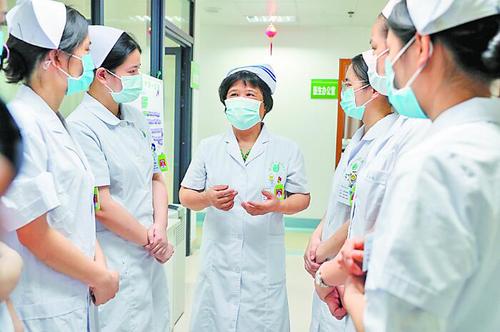 住桂全国政协委员、南宁市第四人民医院艾滋病科护士长杜丽群，主动申请前往抗疫一线。图为杜丽群在给年轻护士们传授经验。