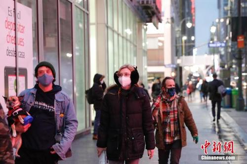 当地时间1月26日，美国纽约曼哈顿街头戴着口罩的行人。中新社记者 廖攀 摄