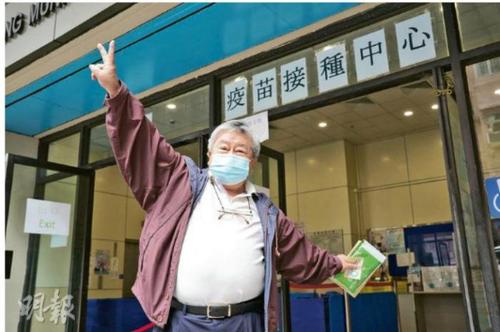 图为70岁香港市民文先生接种国产新冠疫苗后心情大好，比“v”手势。图片来源：香港《明报》