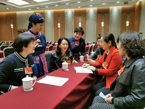 杨远艳委员（左三）与其他全国政协委员在讨论交流  李芳林 摄