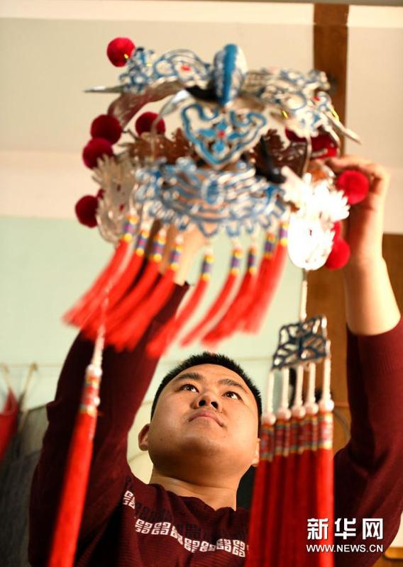 3月16日，河北石家庄的戏曲盔头制作维修师朱宝辉在整理盔头。