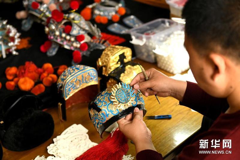 3月16日，河北石家庄的戏曲盔头制作维修师朱宝辉在进行盔头制作中的点绸工序。1