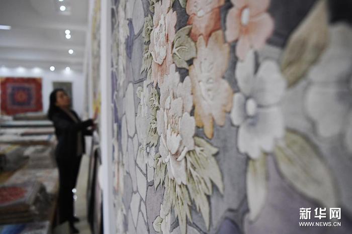 黄晶蓉在天水新天丝毯有限公司成品展室内查看丝毯成品（4月12日摄）。新华社记者 杜哲宇 摄