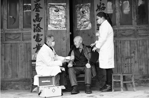 陈伯兴（左）、史勋琼（右）为苗族村民测量血压