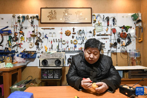 赵伟在工坊内进行葫芦烙画创作（2月9日摄）。 新华社记者 孙凡越 摄