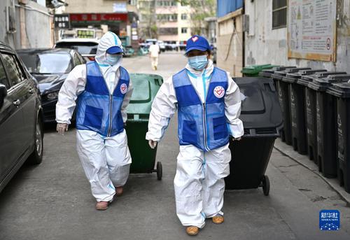 4月4日，在海口市琼山区一个封控居民小区内，志愿者清理垃圾。4