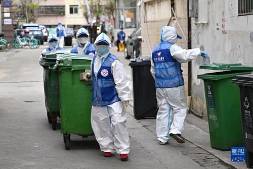 4月4日，在海口市琼山区一个封控居民小区内，志愿者清理垃圾。