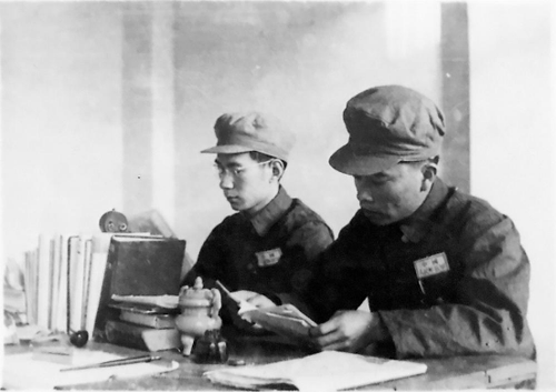 ▶1949年6月，马龙章（左）在学习社会发展史。