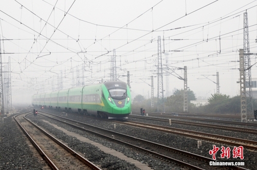 资料图：2022年12月23日拍摄的“绿巨人”复兴号动车组列车快速通过新成昆铁路峨眉至冕宁段。 中新社记者 刘忠俊 摄