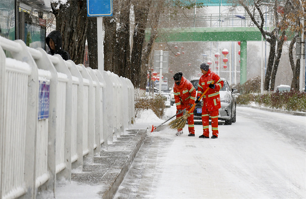 在乌鲁木齐大街小巷，环卫工人扫雪除冰，确保群众出行安全。谢龙 摄