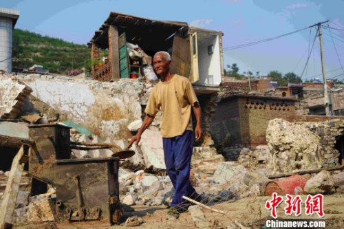贵泉村村民董超站在儿子家被冲毁的房屋旁。　张帆 摄