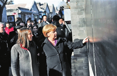 2012年2月，德国总理默克尔行走在南锣鼓巷。供图/Cnsphoto
