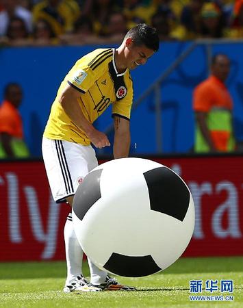 6月19日，哥伦比亚队球员詹•罗德里格斯在场内捡起一个充气足球。当日，在巴西首都巴西利亚马内•加林查国家体育场进行的2014年巴西世界杯小组赛C组比赛中，哥伦比亚队对阵科特迪瓦队。 新华社记者刘彬摄