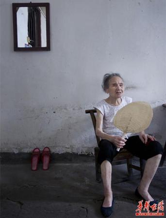 　90岁的王仲莲如今已患有间歇性的老年痴呆，时而清醒、时而糊涂。图为王仲莲老人静坐在屋内，摇着蒲扇。