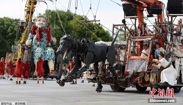 当地时间2014年7月25日，为纪念第一次世界大战爆发100周年，英国利物浦市迎来法国著名木偶剧团皇家豪华的3个巨型木偶，聆听木偶们讲述的一战故事。图为3米高的宠物狗。