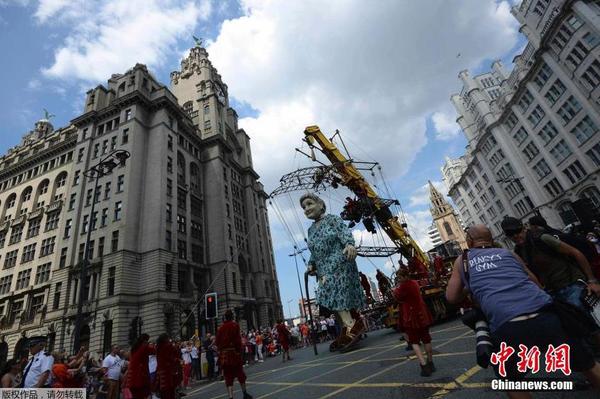 当地时间2014年7月25日，为纪念第一次世界大战爆发100周年，英国利物浦市迎来法国著名木偶剧团皇家豪华的3个巨型木偶，聆听木偶们讲述的一战故事。图为身高7.5米的“老奶奶”。