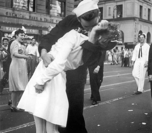 图为当地时间1945年8月14日，纽约市庆祝二战结束，一名水兵和一名护士在曼哈顿时报广场激情拥吻。这一镜头正巧被摄影师拍成照片,并取名为“胜利之吻”。