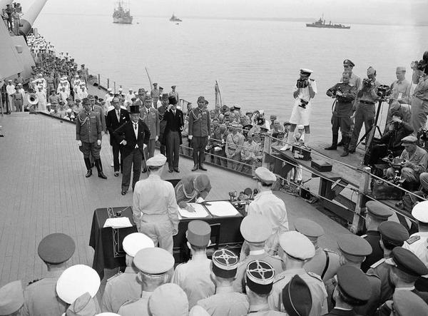 1945年9月2日上午9时，东京湾，密苏里号战列舰上的日本投降文件签署仪式。这张照片里，梅津美治郎将军代表日本武装力量签署投降书，（他身后戴着大礼帽的）日本外相重光葵之前已经代表日本政府签字。