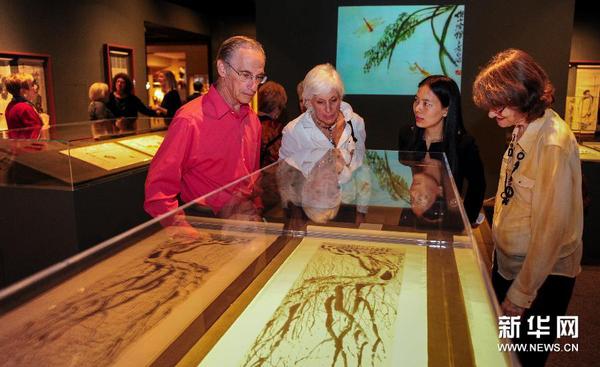 4月10日，在美国洛杉矶宝尔博物馆，观众在湖南省博物馆工作人员（右二）的带领下欣赏齐白石的画作。