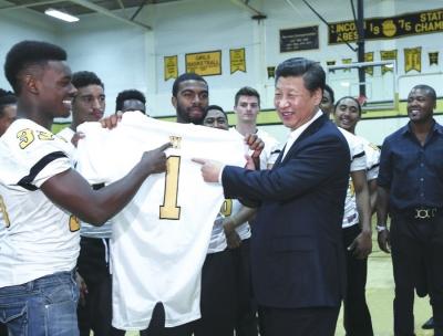 9月23日，国家主席习近平参观美国塔科马市林肯中学，接受学生们赠送的橄榄球衣。新华社记者 兰红光 摄