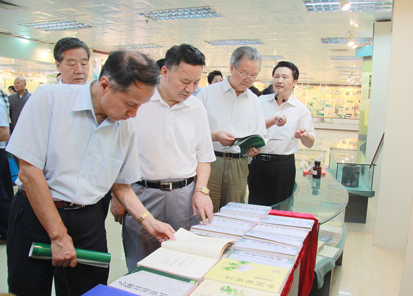 在广西中医药大学医史馆，考察组成员翻阅壮医理论著作。