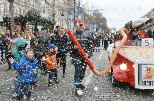 1月1日，在法国巴黎，一辆花车在香榭丽舍大街上喷洒彩色纸屑。