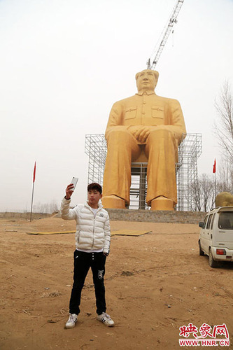 记者在现场看到，这座雕像坐北朝南，毛主席呈坐立状，由钢筋和水泥筑成，外面一层被涂上了金色漆，旁边还有脚手架，不时有群众开车慕名到来，在毛主席像前拍照留念。