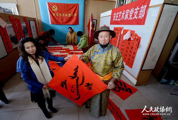 北京宋庄艺术家党支部书记巴特尔把用蒙汉两种文字写好的春联送给蒙族在京的老乡，祝愿新年吉祥。_副本