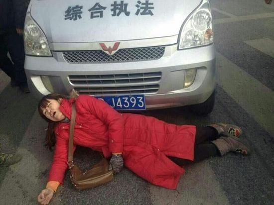 试图阻挡的红衣女子躺在地上。视频截图