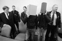当地时间2月24日，德国科隆，涉嫌新年夜性侵、抢劫案的嫌疑人在出庭时，用文件夹遮住自己的脸。