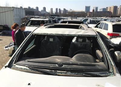 25日，天津“中电物流”停车场，购车者正在参观天津港爆炸受损车辆。